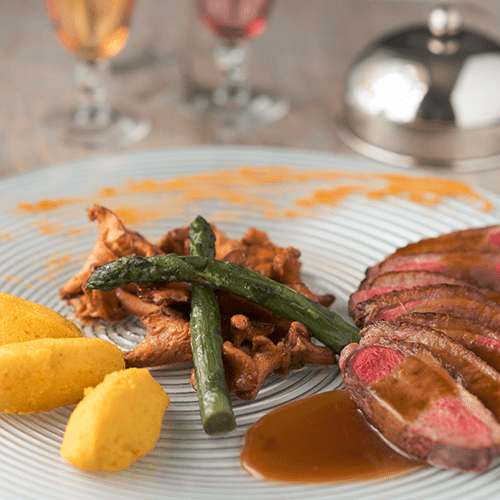 Filet de canard laqué au miel & piment d’Espelette Famille Mary, polenta crémeuse, girolles et asperges.